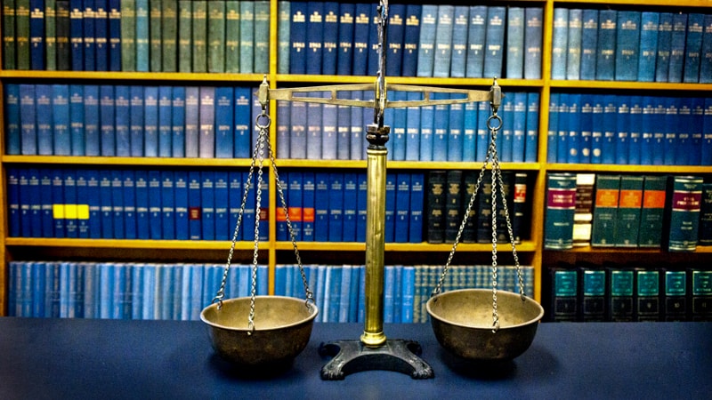 photo of the scales of justice in front of law books