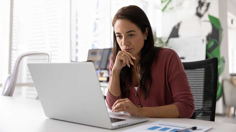 A person looking seriously at a laptop screen