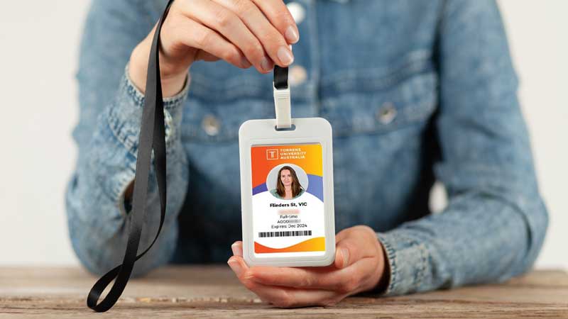 Person holding a student ID card on a lanyard