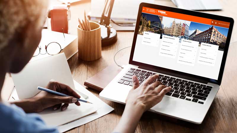 An international student on a laptop looking at the Student Portal
